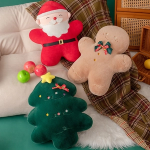 Christmas themed plush pillows with Santa, gingerbread man and tree on a cozy sofa