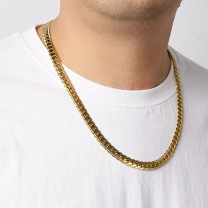Close-up of gold stainless steel Cuban link necklace with embossed NK pattern on a model
