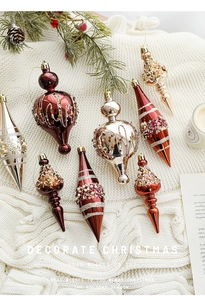 Detail of elegant champagne and gold Christmas ornaments on a cozy knit fabric background