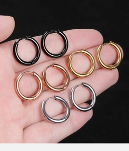 Close-up of four minimalist stainless steel hoop earrings in black, gold, rose gold and silver