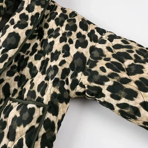 Macro detail of diamond quilted leopard print jacket with dark green contrast piping