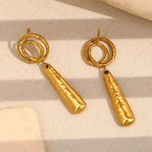 Détail de boucles d'oreilles pendantes en plaqué or 18K avec texture martelée et anneaux