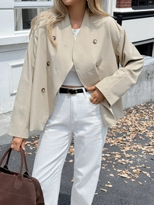 Detail view of a stylish beige double-breasted jacket with premium buttons and loose fit