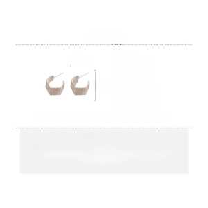 Detail of silver C-shape earrings with textured finish and alloy silver needles