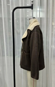 Detail of dark brown faux leather jacket with white faux shearling collar and lapels