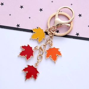 Detail of maple leaf keychain with colorful enamel pendants and golden metal spring clasp