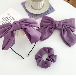 Detailed set of purple satin hair accessories including a bow headband and scrunchie