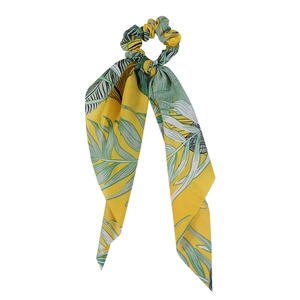 Detail of yellow scrunchie with tropical leaf pattern and long elegant ribbon tails