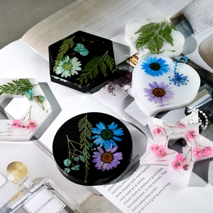DIY geometric resin coasters with embedded dried flowers in black and white styles