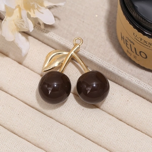 Detailed close-up of a resin dark cherry pendant with metal stem for DIY jewelry making
