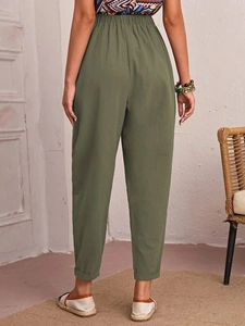 Rear view of olive green cotton linen trousers with elastic waist and rolled cuffs