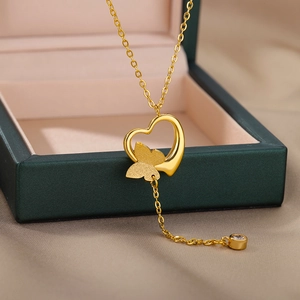 Detail of gold heart necklace with frosted butterfly pendant and zircon on green velvet