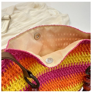 Detail of colorful rainbow straw tote bag with magnetic closure and beige lining