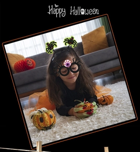 Detail of child wearing black spider headband and pumpkin glasses for Halloween parties