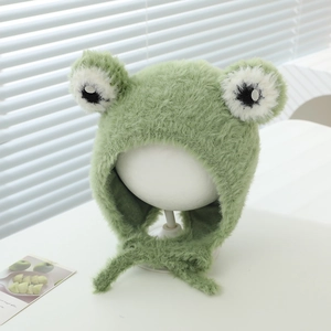 Detail of soft green plush frog hat featuring 3D eyes and windproof earflaps with ties