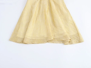 Détail de la robe jaune clair texturée montrant le tissu jacquard et son éclat subtil