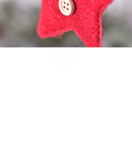 Detail of red felt Christmas star ornament with a rustic wooden button and stitching