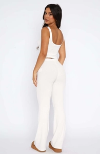 Rear view of white ribbed two-piece set featuring a slim sleeveless top and flared trousers