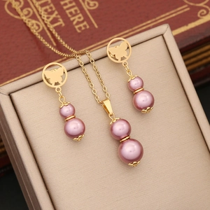 Detail view of gold necklace and butterfly pearl earrings set on a premium jewelry box