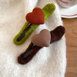 Elegant knit heart hair clip set in green and brown colors on soft fabric background