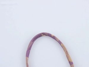 Macro shot of purple jacquard woven shoulder strap showing detailed fabric texture