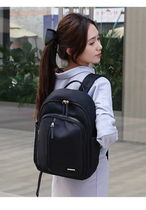 Mujer con mochila de viaje de nailon negro con diseño de múltiples bolsillos al aire libre