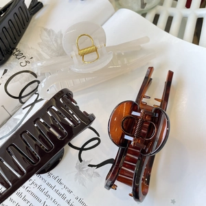 Three large matte hair claws in brown, translucent white and tortoise shell patterns