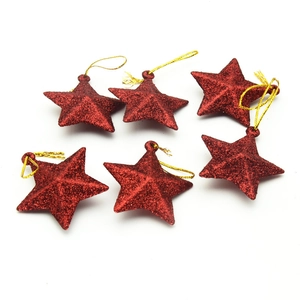 Detail of six red glitter star ornaments with gold hanging strings for Christmas trees