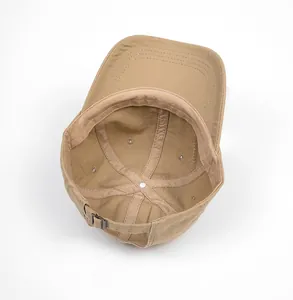 Close-up of khaki cotton baseball cap internal seams with silver metal adjustment buckle