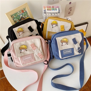 Detail of four colorful nylon crossbody bags with cartoon boy print and buckle closure