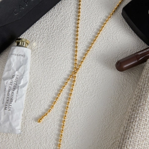 Close-up of a glossy 18K gold stainless steel rice bead chain with a modern finish