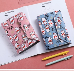 Detail of fabric budget binders with cute cat patterns and metallic snap closures