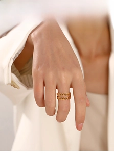 Detail of gold double-layer chain link ring on model with modern industrial aesthetic