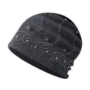 Détail de la maille du bonnet gris foncé avec motifs de perles et de paillettes argentées