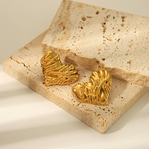 Boucles d'oreilles cœur doré texture lave sur plaques de pierre élégantes