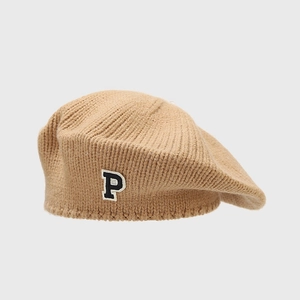 Detail of camel knit beret featuring a vintage P letter patch and soft woolen texture