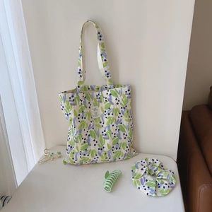 Flat lay of floral cotton tote bag with matching scrunchie and hair claws in soft light