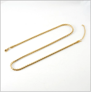 Detailed macro view of gold plated stainless steel S-chain with lobster clasp and extender
