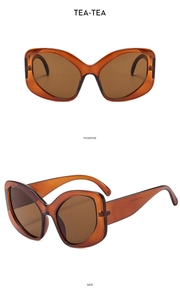 Macro detail of elegant tea-colored cat-eye sunglasses with thick amber frames