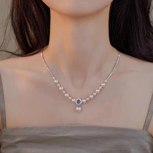 Detail of s925 silver necklace featuring white pearls and a blue gemstone pendant