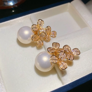 Detailed close-up of elegant pearl flower earrings with gold finish and zircon stones
