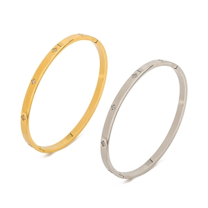 Detail of gold and silver stainless steel bangles with star-set cubic zirconia stones