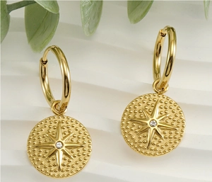 Gros plan détaillé des boucles d'oreilles étoile dorées 18 carats avec zircon brillant