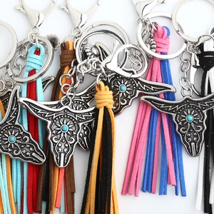 Detail of bohemian cow skull keychains with turquoise stones and colorful tassels