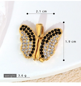 Macro detail of butterfly pendant with black and white cubic zirconia and gold finish