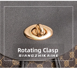 Detail of golden oval twist lock closure on textured grey and brown patterned leather bag