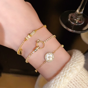 Detailed view of three gold-plated bracelets featuring a clover charm and pavé crystals