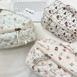 Three quilted makeup bags featuring cute cartoon prints and branded ribbon zipper pulls
