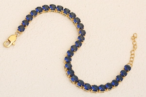 Detail of 18K gold plated tennis bracelet with blue zircons and lobster clasp closure
