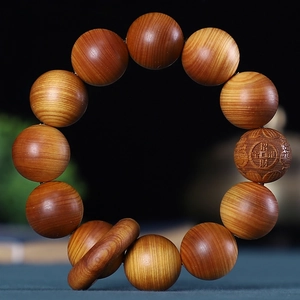 Détail macro de perles en bois de Thuja avec grain d'huile fin et gravure de chance